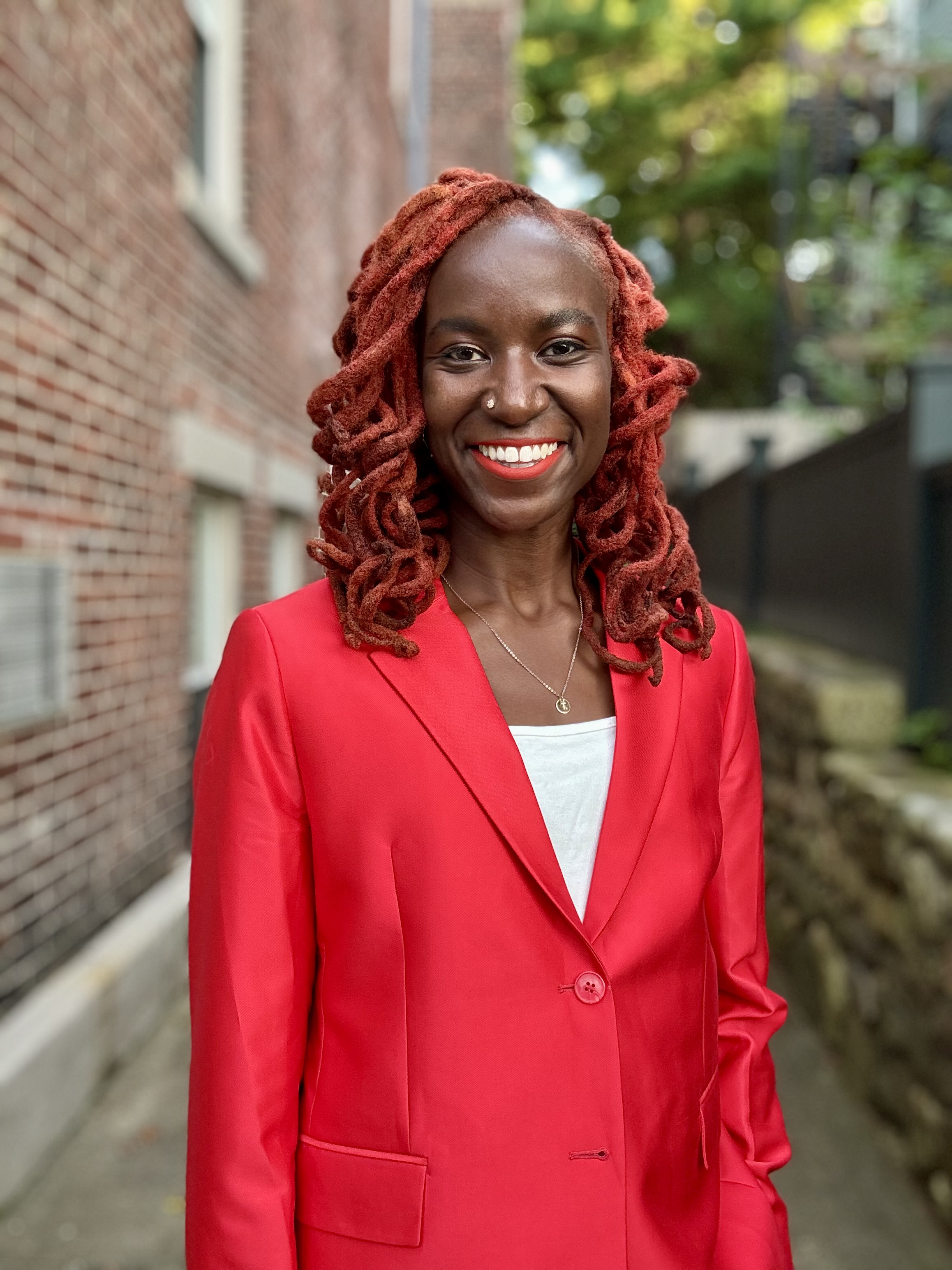 title Reese wearing a red suit and smiling for the camera